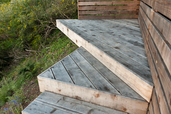 The front edge of this triangular deck catilevers over the beam for a feeling of levitation above the grade.