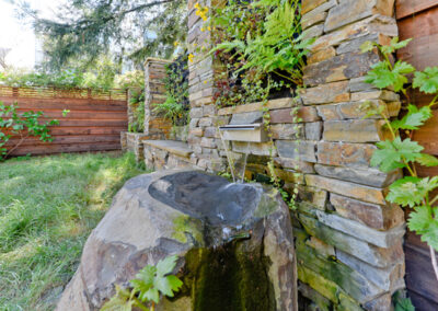 Stainless steel scupper, basalt boulder, and recirculating water