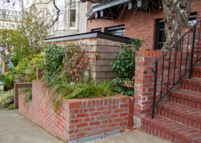 Pacific Heights Jewel: Creative brickwork fronting a 100-year-old house with custom bike shed and family heritage tree as focal point.
