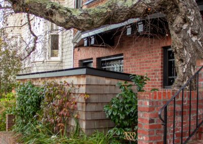 Pacific Heights Jewel: Creative brickwork fronting a 100-year-old house with custom bike shed and family heritage tree as focal point.